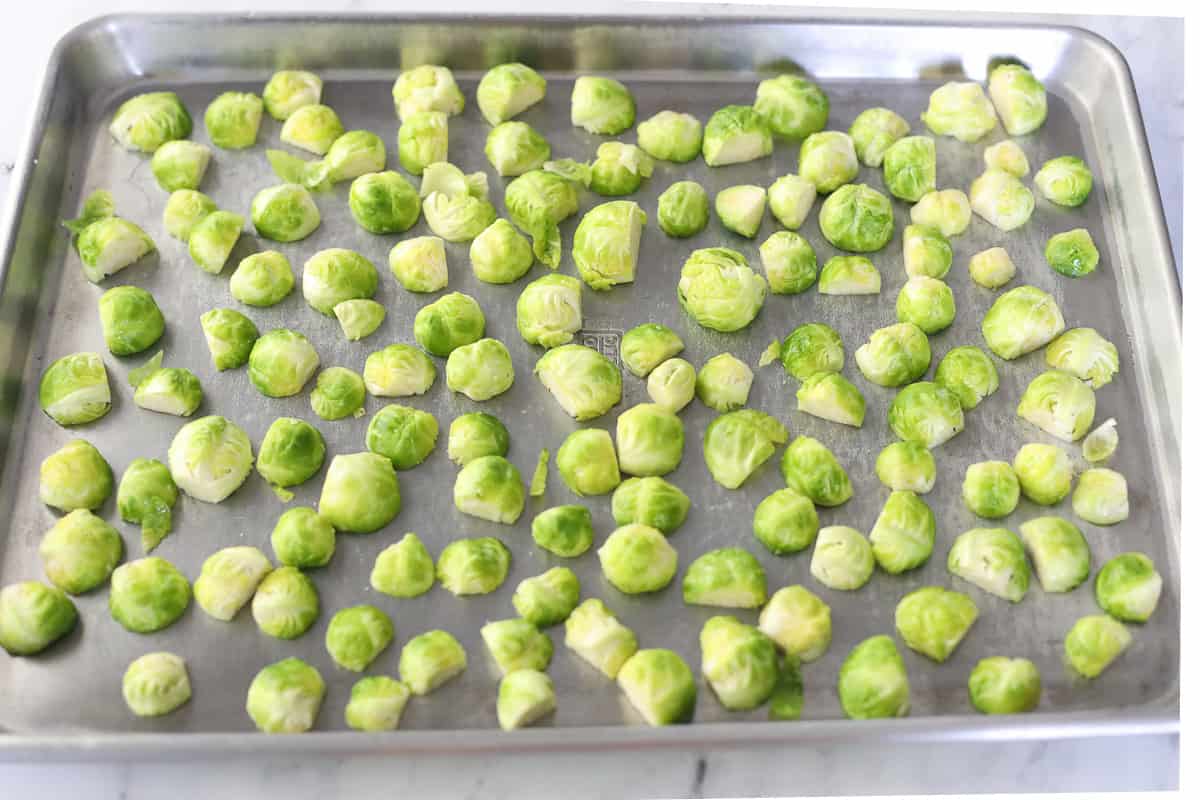 Brussels sprouts on a sheet pan with cut sides down.