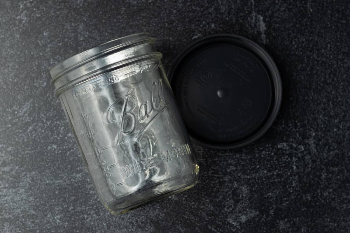 Mason jar with gray lid next to it.