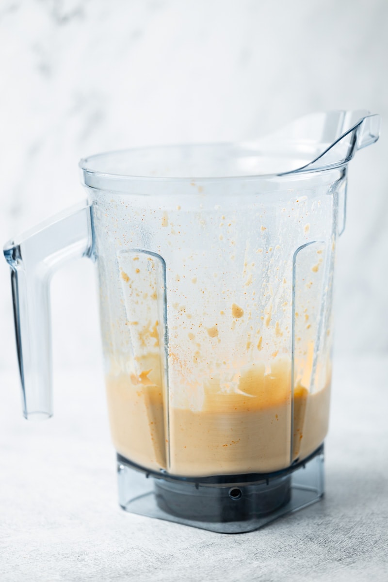 Flourless cheese sauce ingredients blended in a Vitamix container, verticle view.