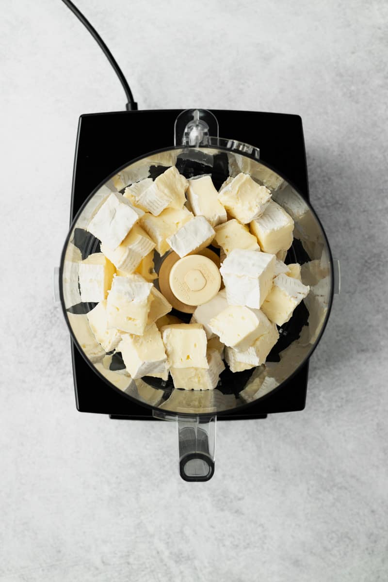 Cubed brie cheese in a food processor.