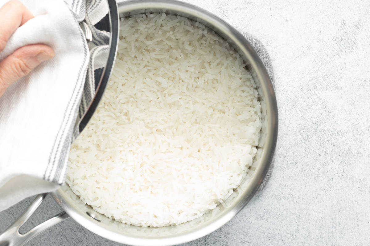 Cooked Jasmine rice in a medium-sized stainless-steel pot, ready to be fluffed.