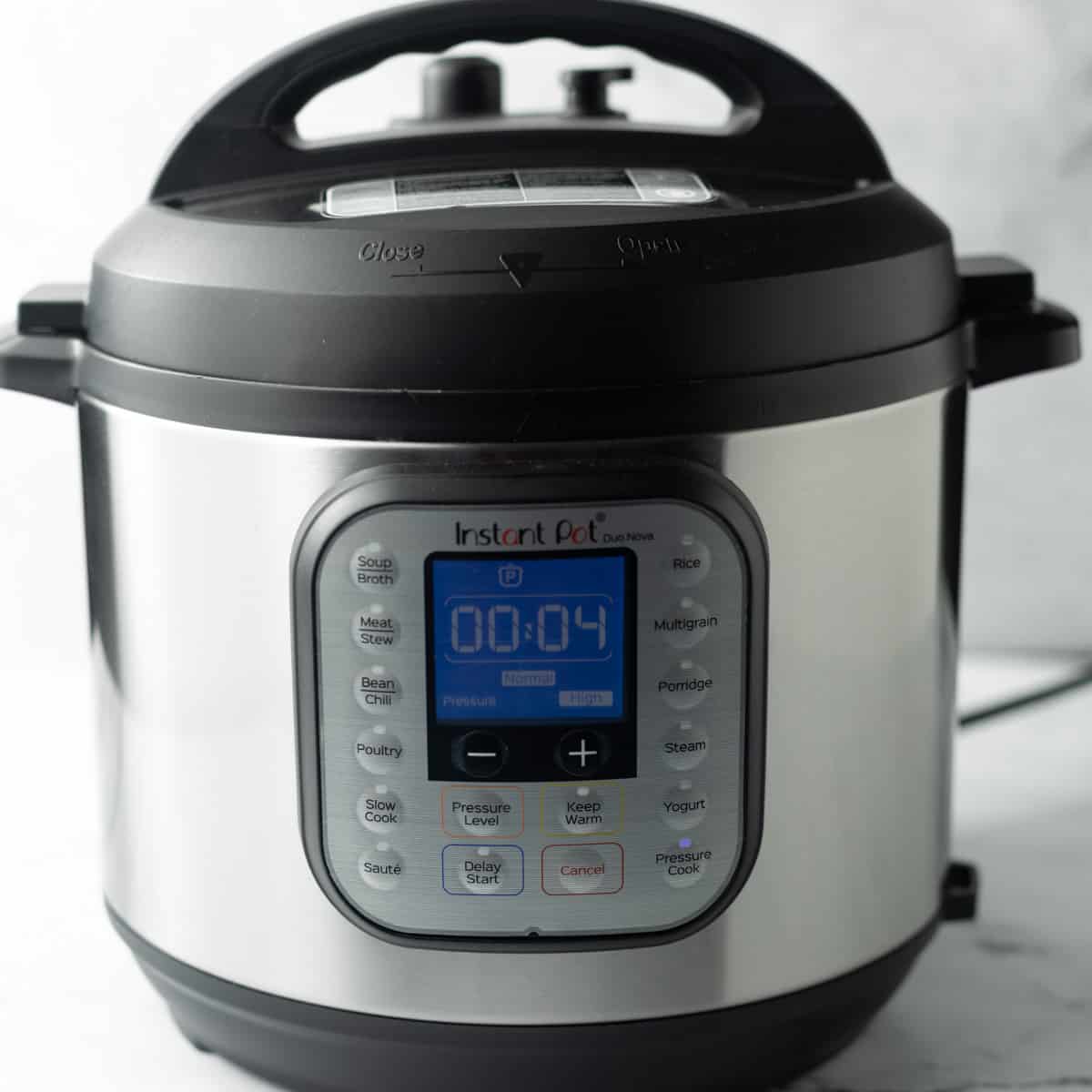 Instant Pot with lid attached is shown and the digital display is set to pressure cook for 4 minutes.
