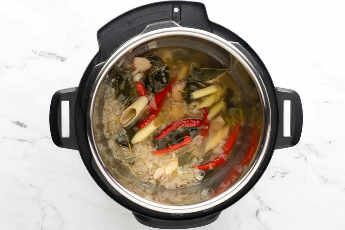 Instant Pot with the lid removed shows the pressure-cooked soup base ingredients.