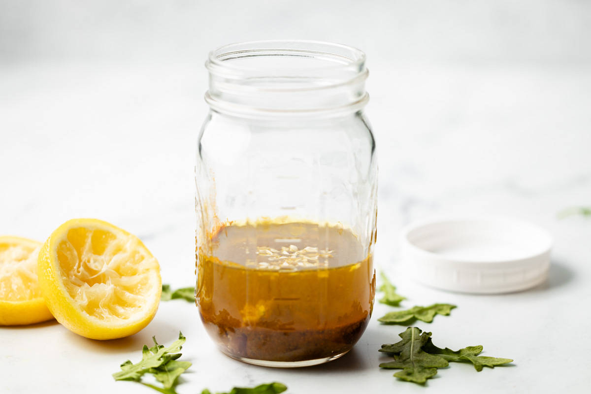 Curry salad dressing ingredients added to a mason jar.