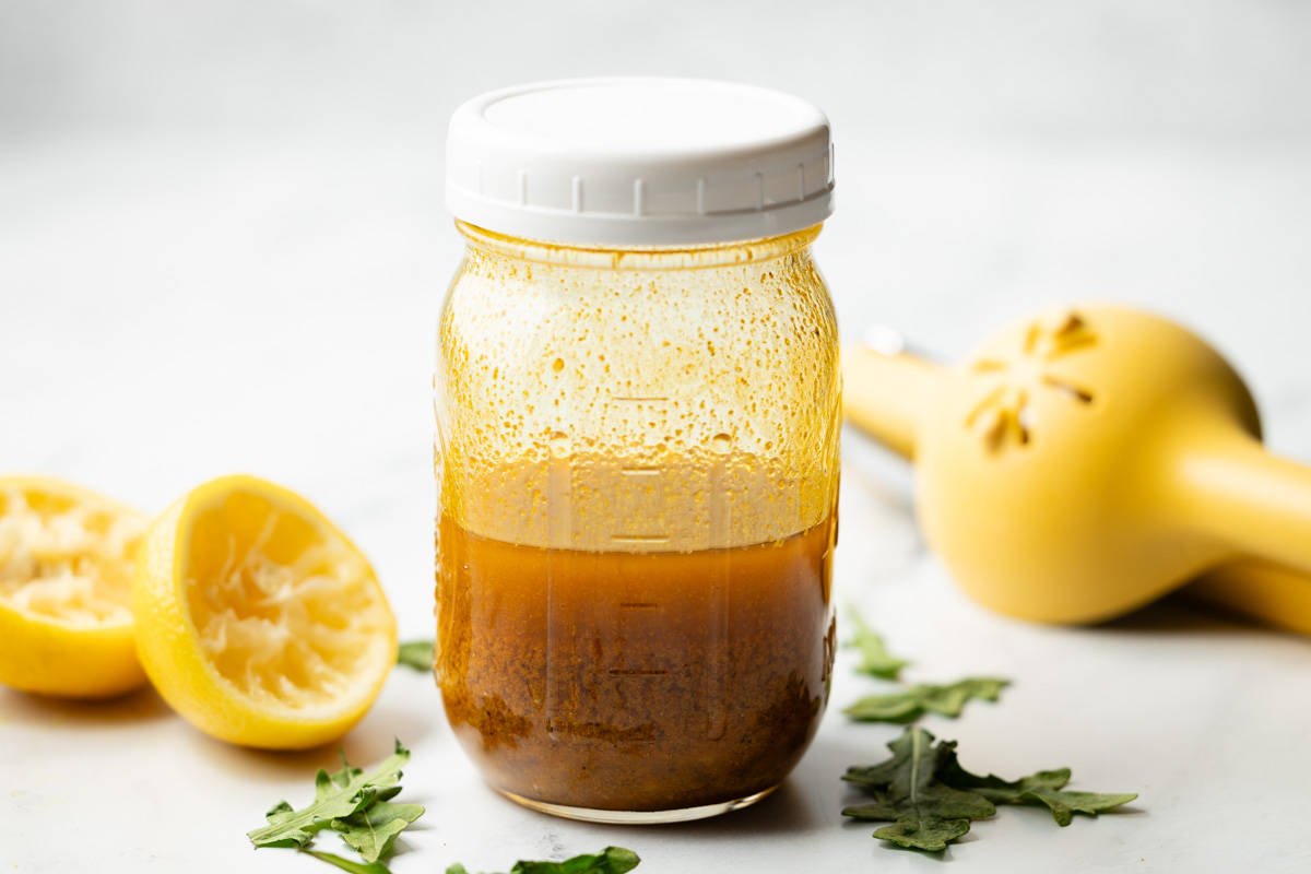 Curry salad dressing ingredients added to a mason jar and hand-shaken to combine.