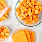 Sliced, cubed, and cut sweet potatoes are in separate storage containers on a textured grey counter.