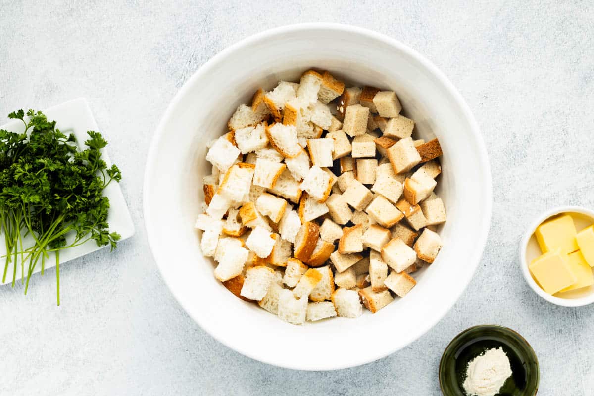 Cubed bread placed in a white mixing bowl.