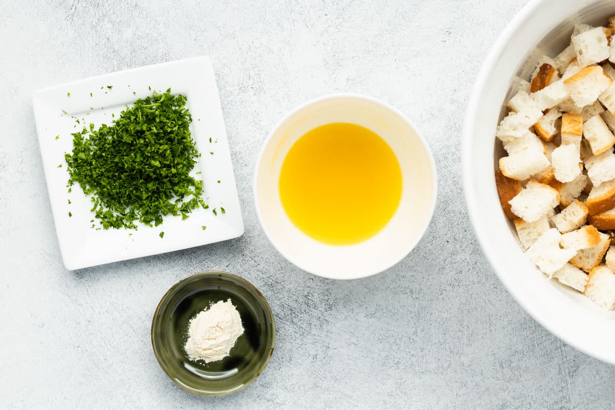 Butter, parsley and garlic powder in separate containers, ready to be combined.