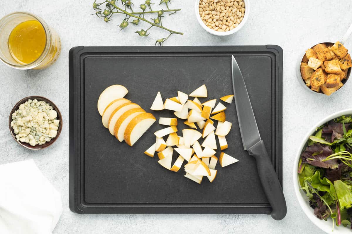 Chopped Asian pear on a black cutting board.