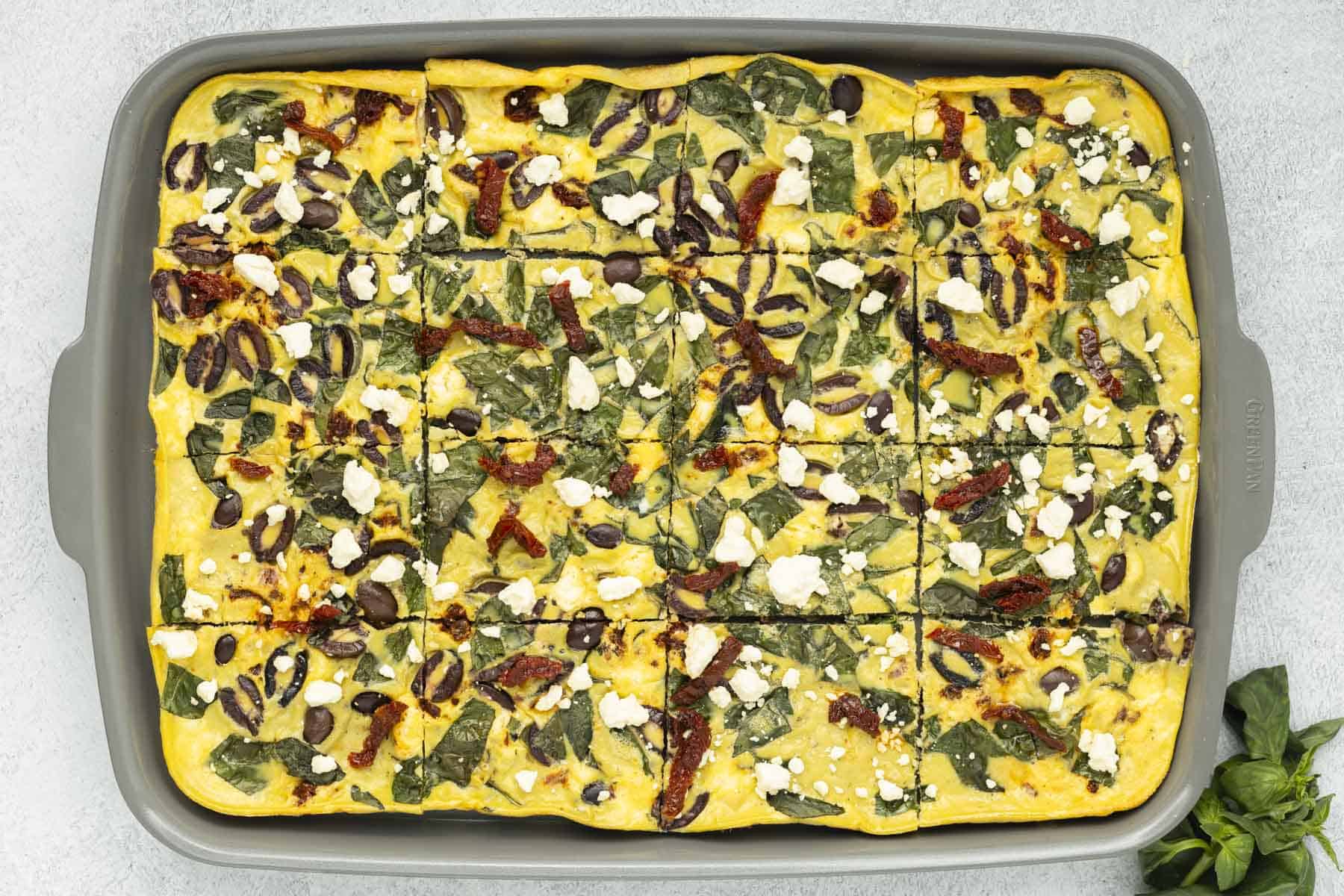 Sheet pan eggs sliced into 16 portions on a baking sheet.